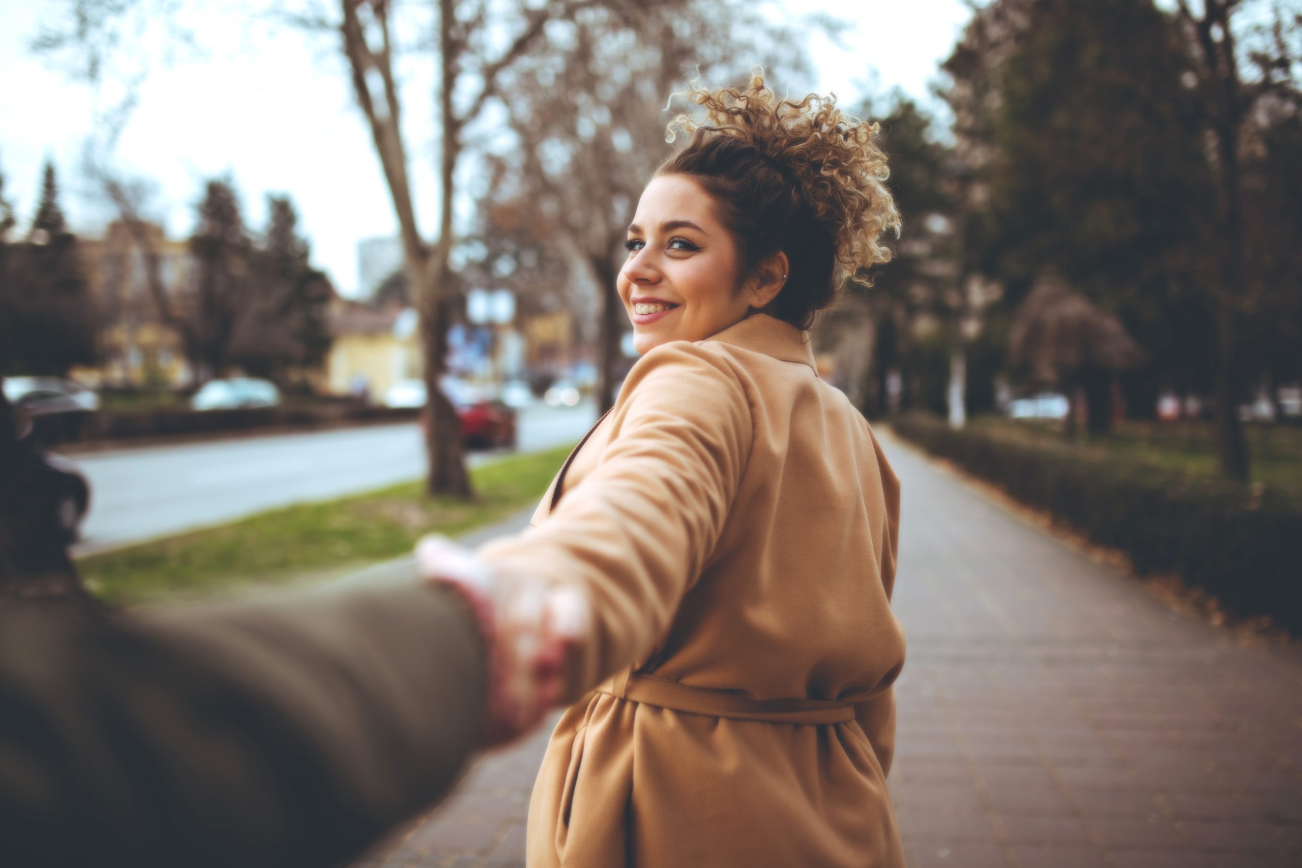 woman looking back and laughing at a local single man in the park