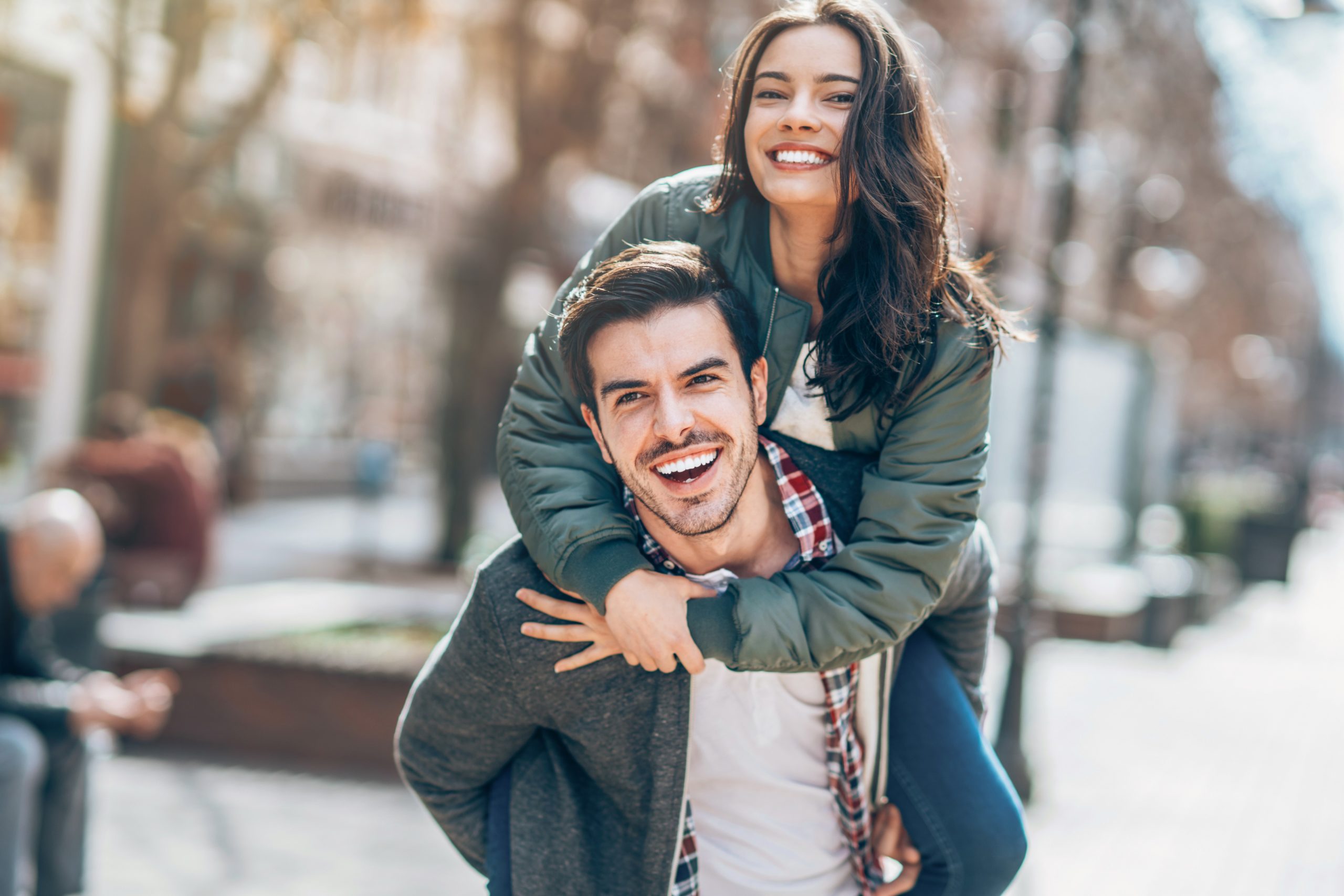 Couple piggy backing and laughing on the streets of Nashville