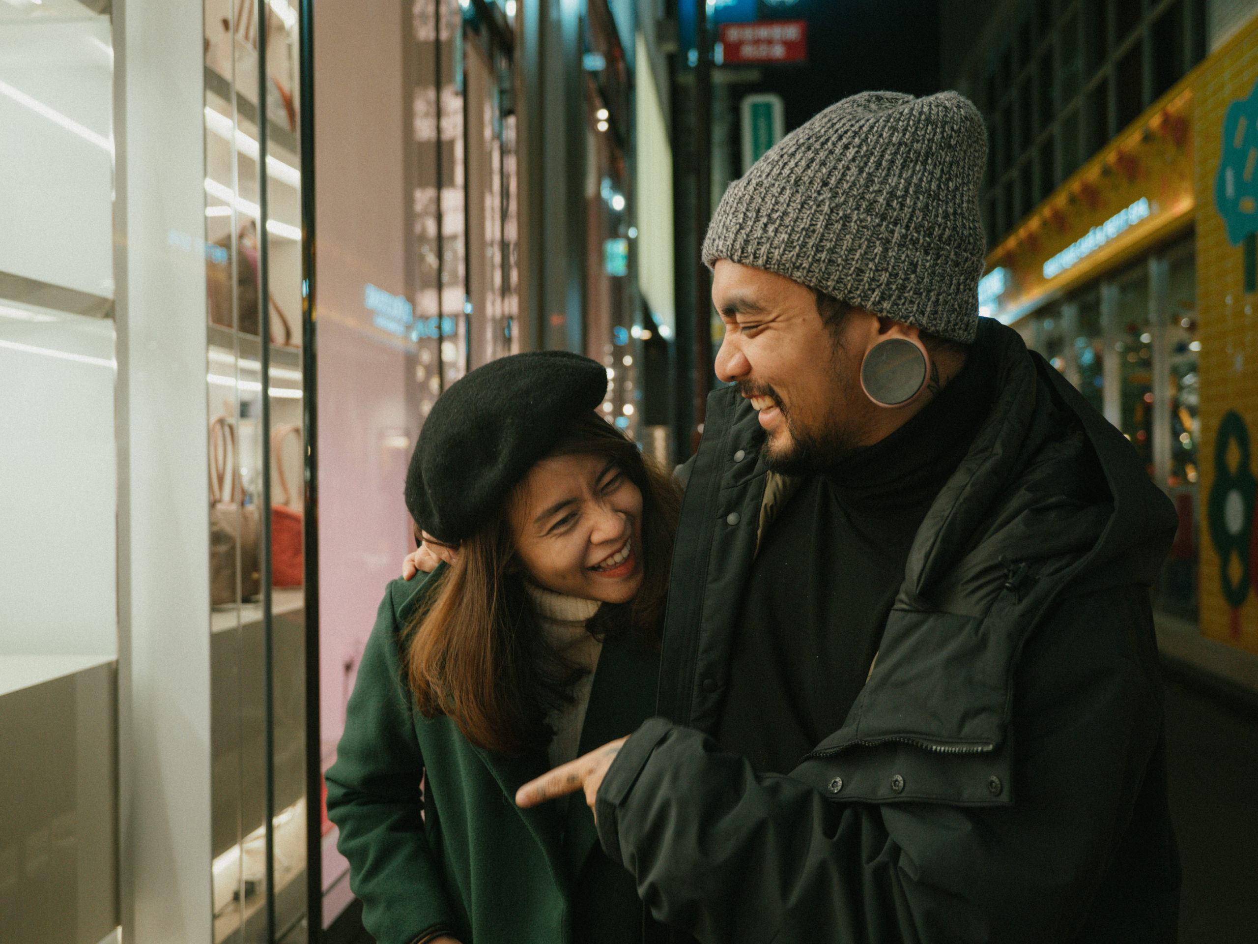Happy couple walking down the street smiling and laughing after meeting on an Asian dating site.