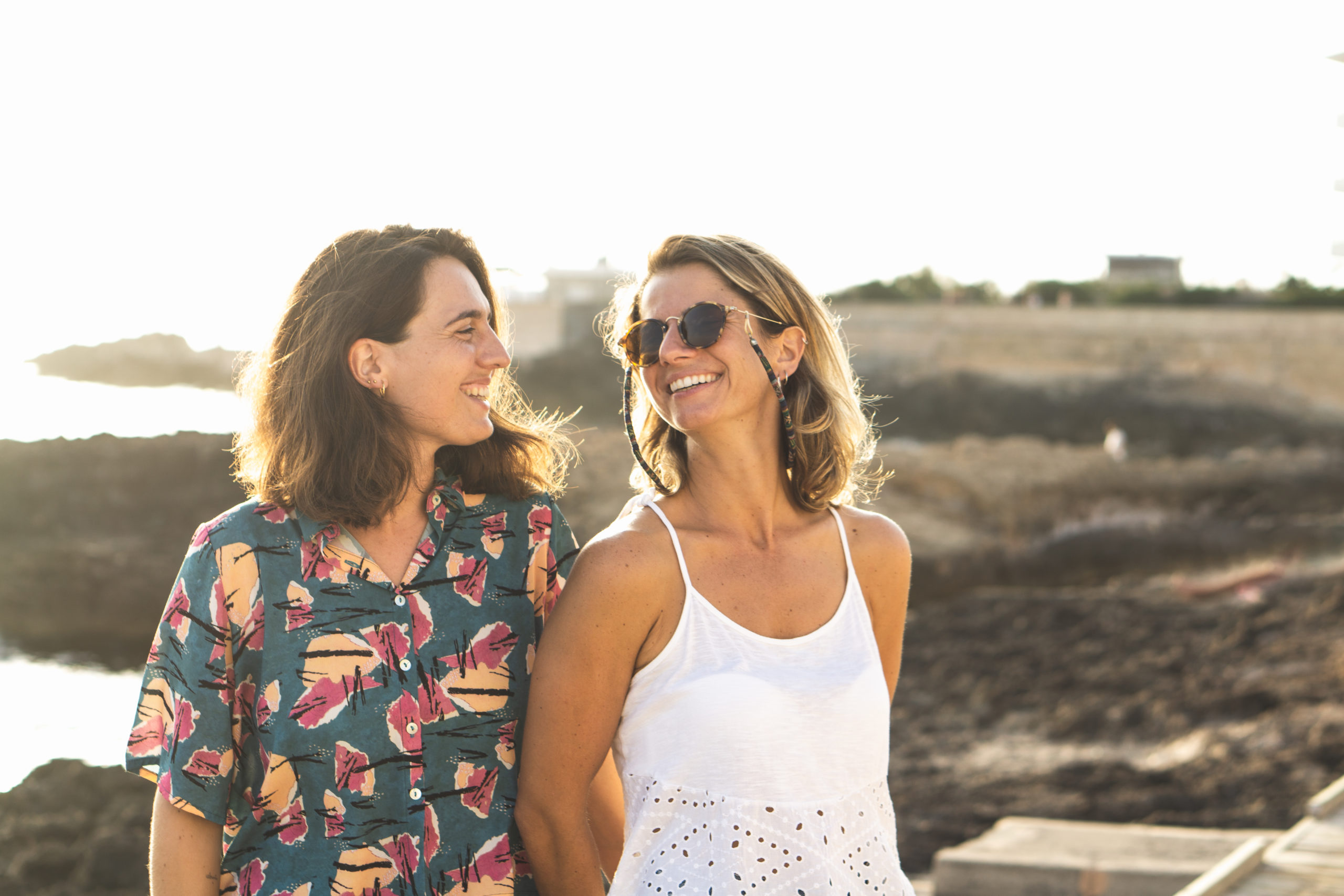 Happy female couple walking together and smiling at each other after meeting online through a dating app for women seeking women.