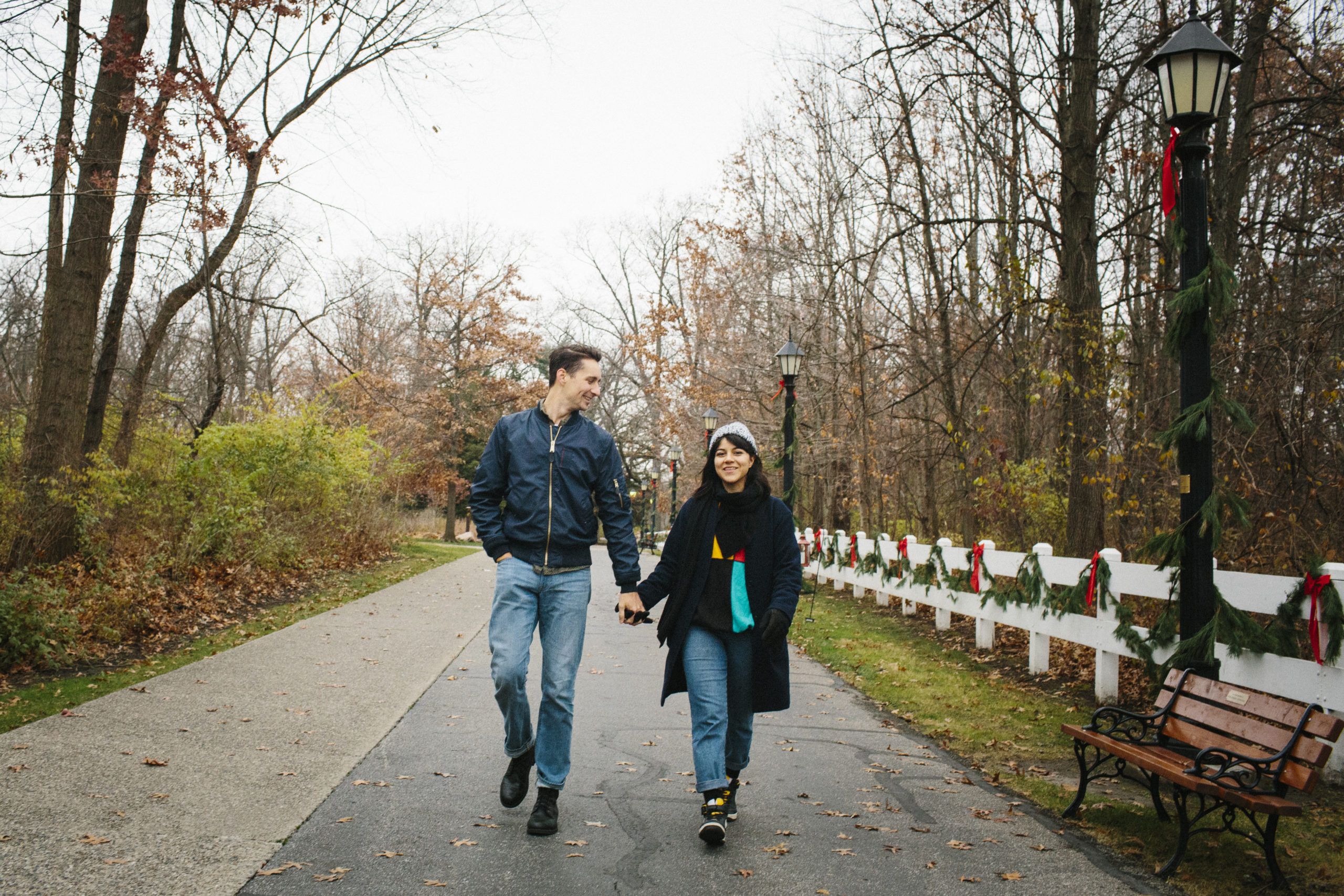Happy, smiling couple walking through park and holding hands while dating in Columbus, Ohio.