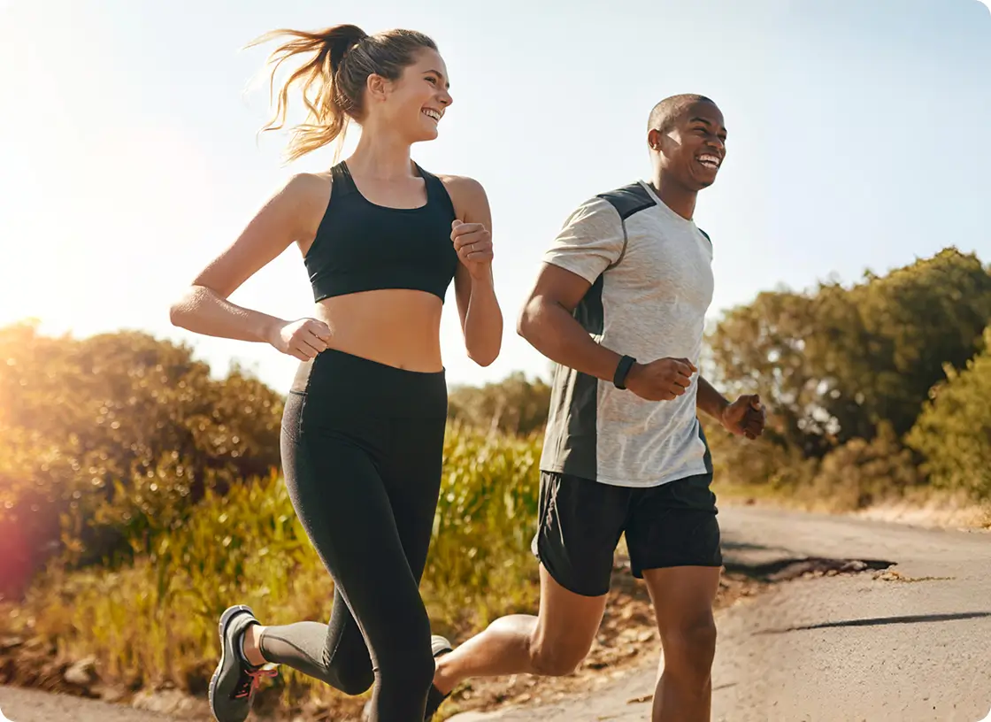 A man and woman jogging along a road